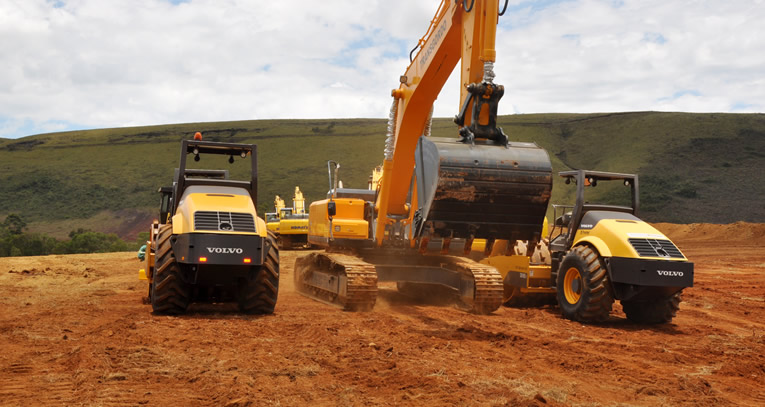 Escavadeira e rolos compactadores preparando terreno